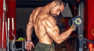A fit, shirtless man showcasing biceps while lifting a dumbbell in a gym setting. — Natural Care and Balance with Ayurvedic M